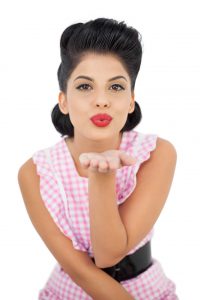 Pleased black hair model blowing a kiss to the camera
